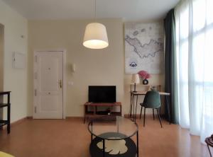 sala de estar con mesa de cristal y TV en Bonito y acogedor estudio - Nice and cozy studio, en Málaga