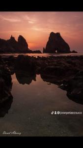 a reflection of a sunset in a body of water at Hotel Restaurante el Fornon in Novellana