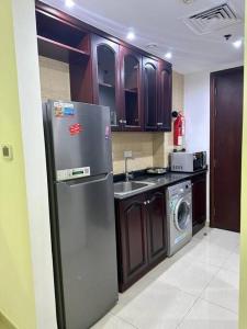 uma cozinha com um frigorífico de aço inoxidável e uma máquina de lavar louça em Home away from Home em Ras al-Khaimah