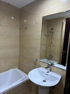 a bathroom with a sink and a tub and a mirror at Home away from Home in Ras al Khaimah +16 photos