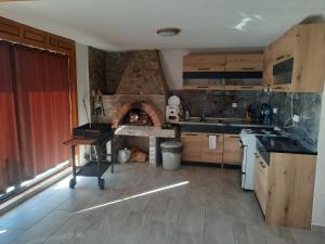 a kitchen with a stone oven in the middle at Къща за гости Люляк 