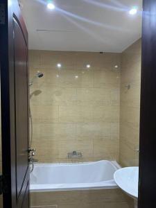 a bathroom with a bath tub and a sink at Home away from Home in Ras al Khaimah