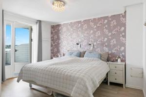 a bedroom with a bed with a pink floral wall at 3-bedroom terrace house with incredible sea views in Moss