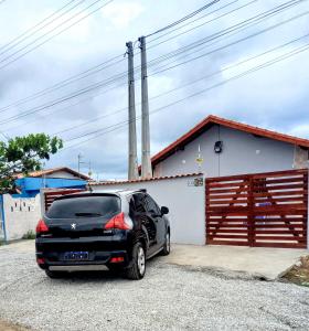 a black car parked in front of a garage at Doce Refugio Itanhaém in Itanhaém
