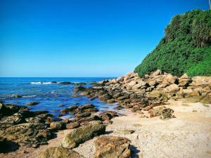 a group of rocks on a beach next to the ocean at Doce Refugio Itanhaém in Itanhaém
