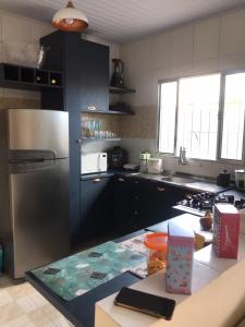 a kitchen with a stainless steel refrigerator and a counter at Doce Refugio Itanhaém in Itanhaém