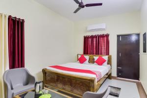 a bedroom with a bed and a desk and a chair at OYO Flagship Hotel Vaiko in Khandagiri