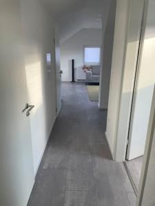 een lege hal met een deur en een kamer met een bank bij Boarding Suite in Wendlingen am Neckar