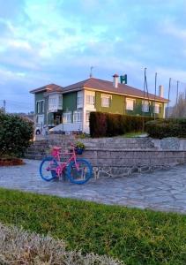 a pink bike parked in front of a house at Hotel Restaurante el Fornon in Novellana