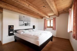 a bedroom with a large white bed with wooden ceilings at Villa Tegernsee - Exclusive Lakefront Villa with private Zirben Sauna, 4 Rooms for Family & Friends in Tegernsee