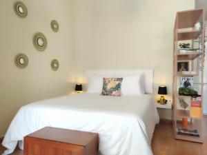 1 dormitorio con 1 cama blanca y 2 estanterías en Bonito y acogedor estudio - Nice and cozy studio, en Málaga