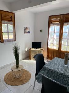 uma sala de estar com uma mesa e cadeiras e uma televisão em KARIFUNA em Le Souffleur