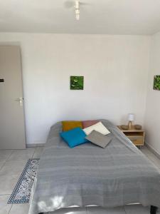 ein Schlafzimmer mit einem Bett mit Kissen darauf in der Unterkunft KARIFUNA in Le Souffleur