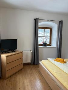 1 dormitorio con 1 cama, TV y espejo en Gasthaus Kirchenwirt, en Schwoich