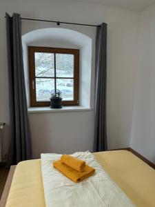 1 dormitorio con cama con espejo y ventana en Gasthaus Kirchenwirt, en Schwoich