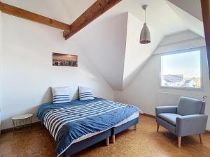 1 dormitorio con 1 cama y 1 silla azul en Grande maison de vacances, en Agon-Coutainville