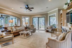 a large living room with a ceiling fan and windows at * Luxury 4500 sf home* Pool Spa * near Lake Austin in Austin