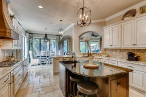 a kitchen with white cabinets and a large island at * Luxury 4500 sf home* Pool Spa * near Lake Austin in Austin