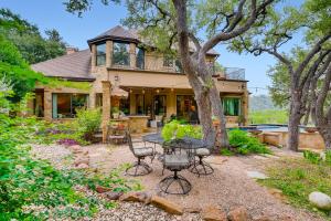 an exterior view of a house with a table and chairs at * Luxury 4500 sf home* Pool Spa * near Lake Austin in Austin