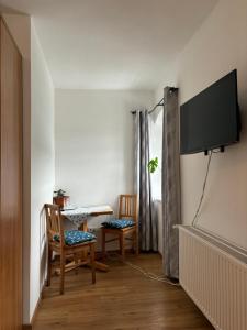 sala de estar con 2 sillas y TV en la pared en Gasthaus Kirchenwirt en Schwoich