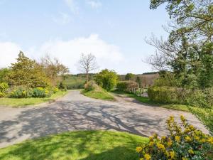 的住宿－2 bed in Hadleigh 87956， ⁇ 曲折的道路,花园中种满了树木和鲜花