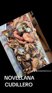 a pile of seafood on a tray on a table at Hotel Restaurante el Fornon in Novellana