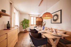 a dining room with a long table and chairs at Villa Tegernsee - Exclusive Lakefront Villa with private Zirben Sauna, 4 Rooms for Family & Friends in Tegernsee +52 photos