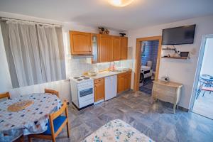 a kitchen with a table and a dining room at Villa Matanov dvorac in Tisno