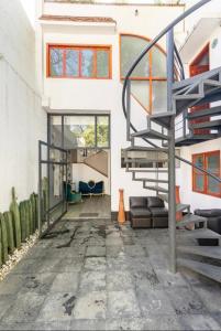una sala de estar con una escalera en una casa en Siete Puertas Coyoacán en Ciudad de México