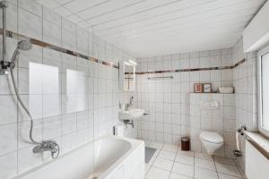 a bathroom with a tub and a toilet and a sink at Charmante & gemütliche Wohnung in Lahnstein