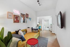 uma sala de estar com um sofá amarelo e uma televisão em Charmante & gemütliche Wohnung em Lahnstein
