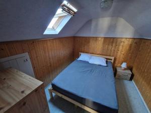 a bedroom with a bed and a skylight at Joli appartement rénové (Hirondelle) in Cornimont