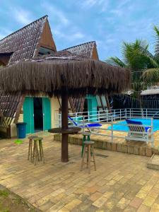 um resort com uma mesa e bancos ao lado de uma piscina em Marcelo Chale em Paraty