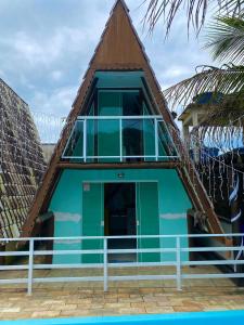 a house with a green door and a balcony at Marcelo Chale in Paraty