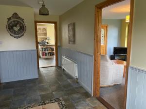 a hallway with a couch and a clock on the wall at Letterfrack Mountain Farm Cottage on farm in village centre in Letterfrack