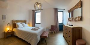 a bedroom with a bed and a dresser with a lamp at La Bellours Chambre D'Hôtes in Cahors