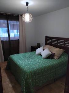 a bedroom with a bed with a green comforter at Una casa con vistas en Galapagar in Galapagar +41 photos