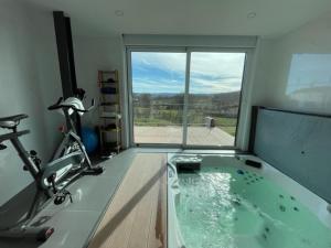 a gym with a jacuzzi tub in a room with a window at Casa do Cabo in Mós