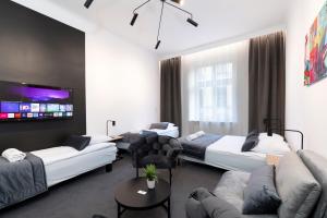 um quarto de hotel com duas camas e um sofá em Rainbow Apartments Old Town na Cracóvia