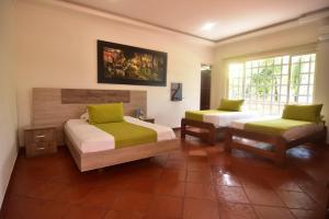 a bedroom with two beds with green pillows at Hotel Los Lagos Centro Vacacional in Monterrey