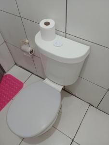 a white toilet in a bathroom with a roll of toilet paper at Tedesco in Palmas