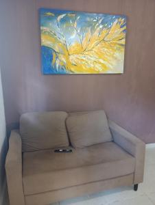 a couch in a room with a painting on the wall at Tedesco in Palmas