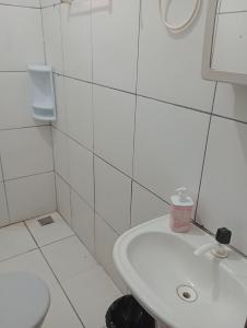 a white bathroom with a sink and a toilet at Tedesco in Palmas