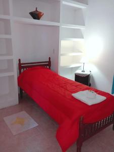 ein Schlafzimmer mit einem roten Bett mit einer roten Decke in der Unterkunft M y M Departamento in Belén