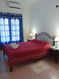 Un dormitorio con una cama roja con toallas. en M y M Departamento en Belén