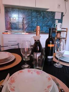 a table with two glasses and a bottle of wine at M y M Departamento in Belén