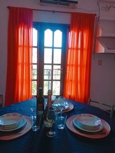 einen Tisch mit Tellern und Gläsern sowie eine Flasche Wein in der Unterkunft M y M Departamento in Belén
