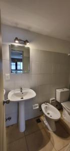 La salle de bains est pourvue d'un lavabo, de toilettes et d'un miroir. dans l'établissement Amplio Studio en Pocitos, à Montevideo