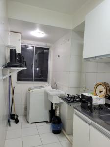 a white kitchen with a sink and a stove at SUA ESTADIA PERFEITA in São Luís
