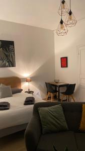 Sala de estar con cama y mesa en Le Studio de Meli, 3 étoiles, 30m2, raffiné, élégant et bien situé en Rochefort